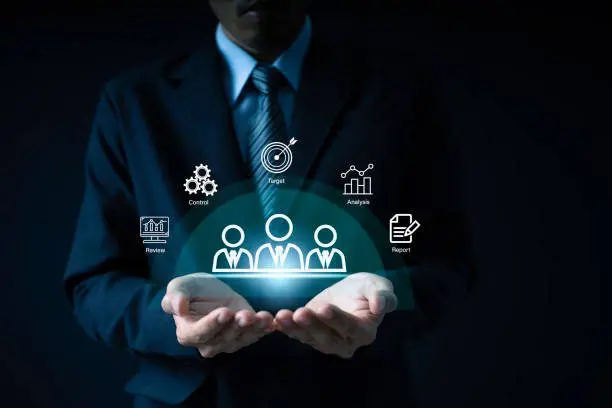 Businessman holding digital icons of teamwork strategy.