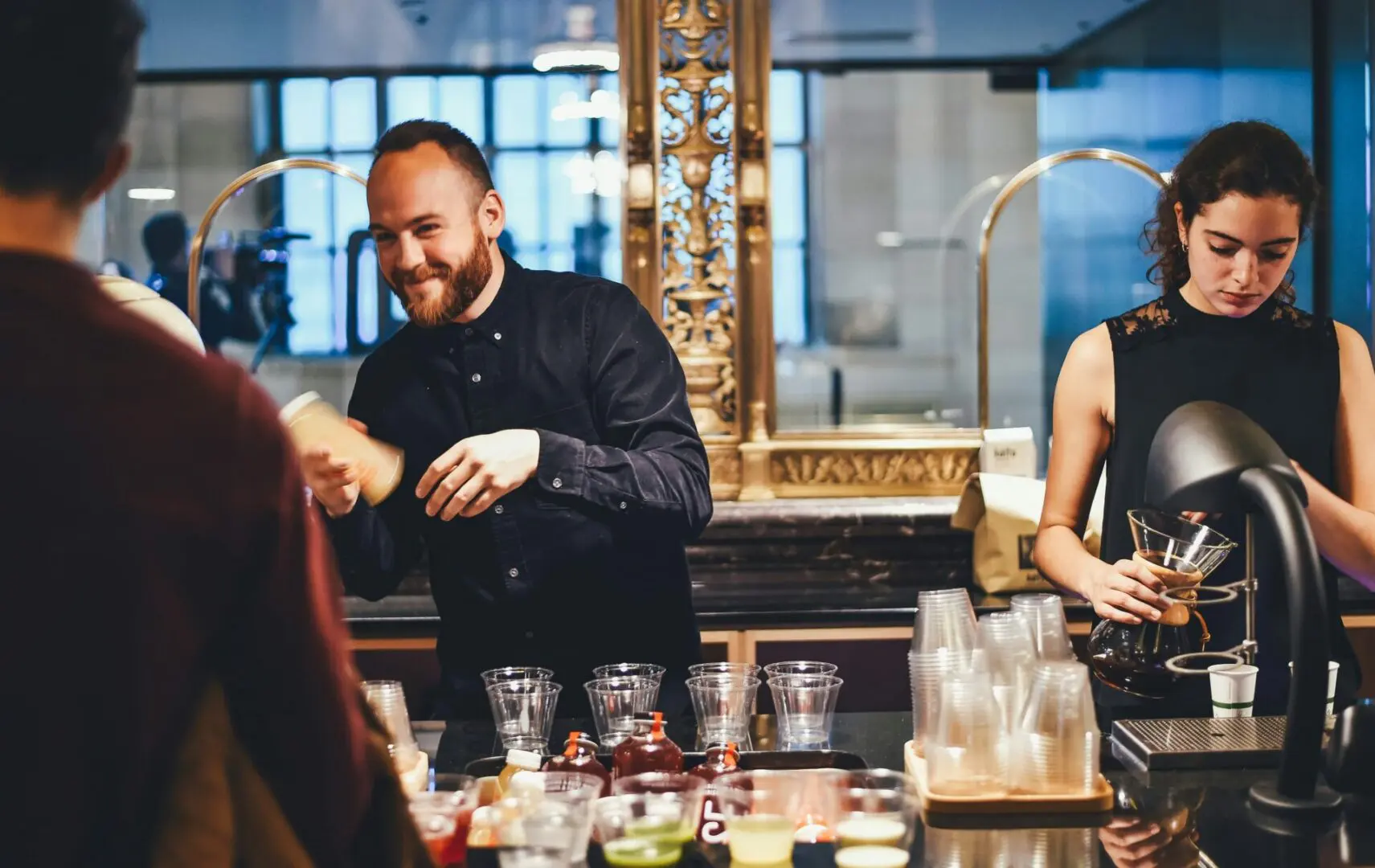 Baristas preparing drinks at busy coffee counter