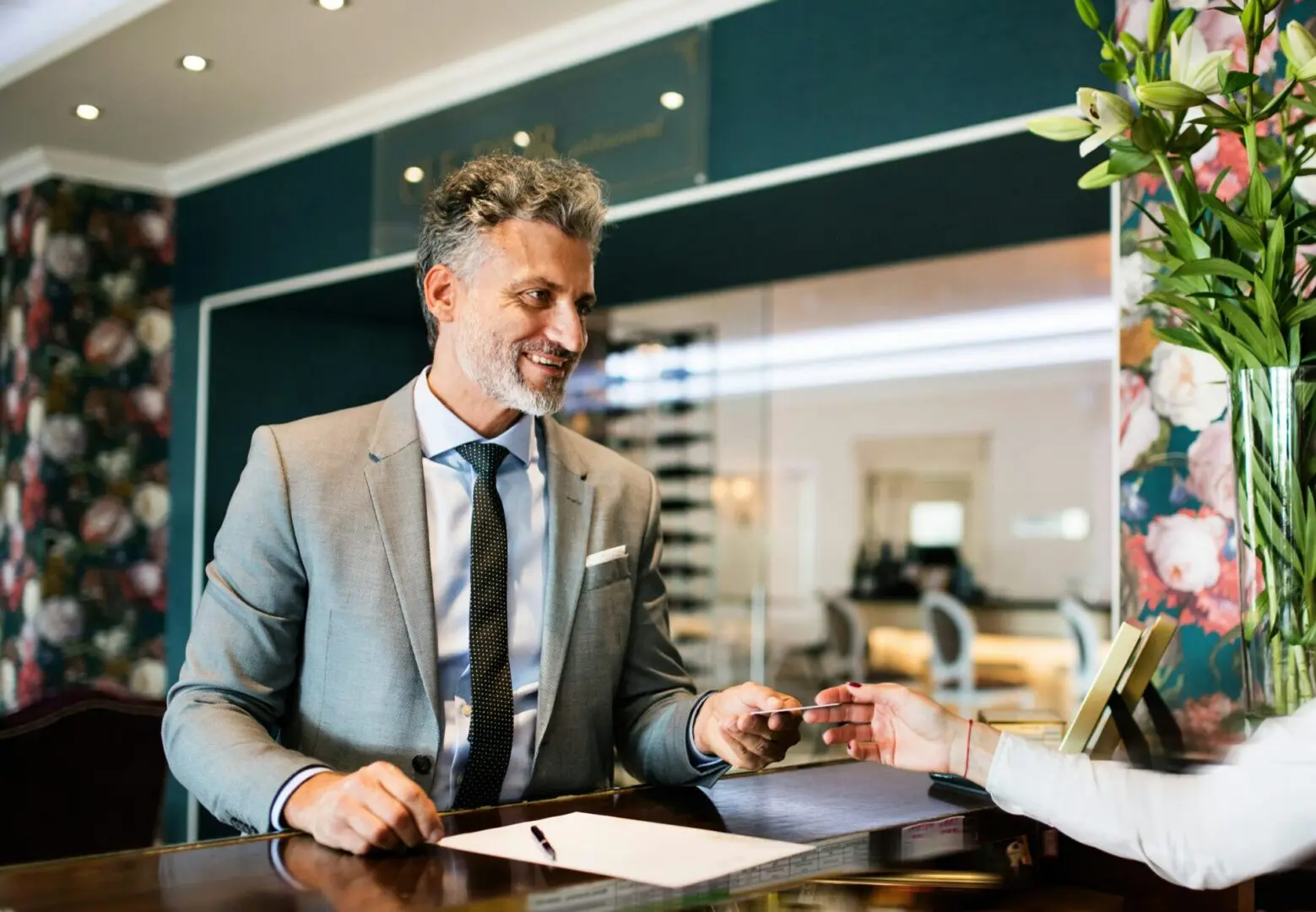 Man checking in at hotel reception desk